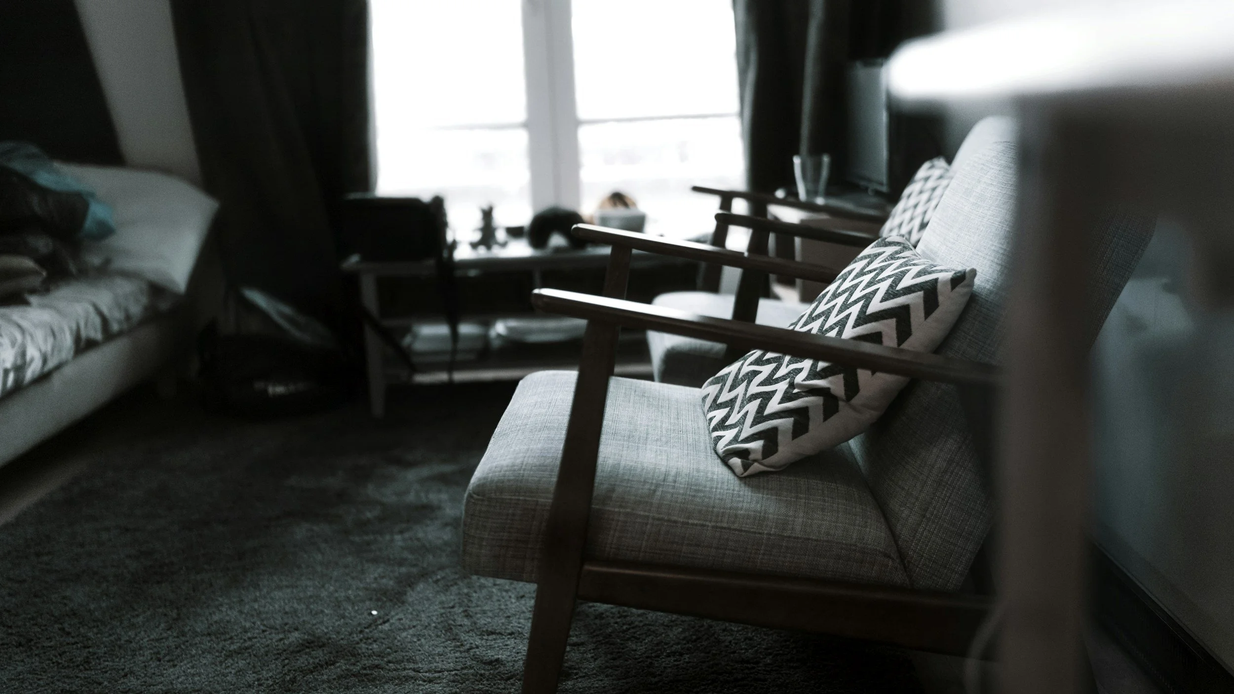 chairs in a dimly lit room across from a couch depicting therapy room