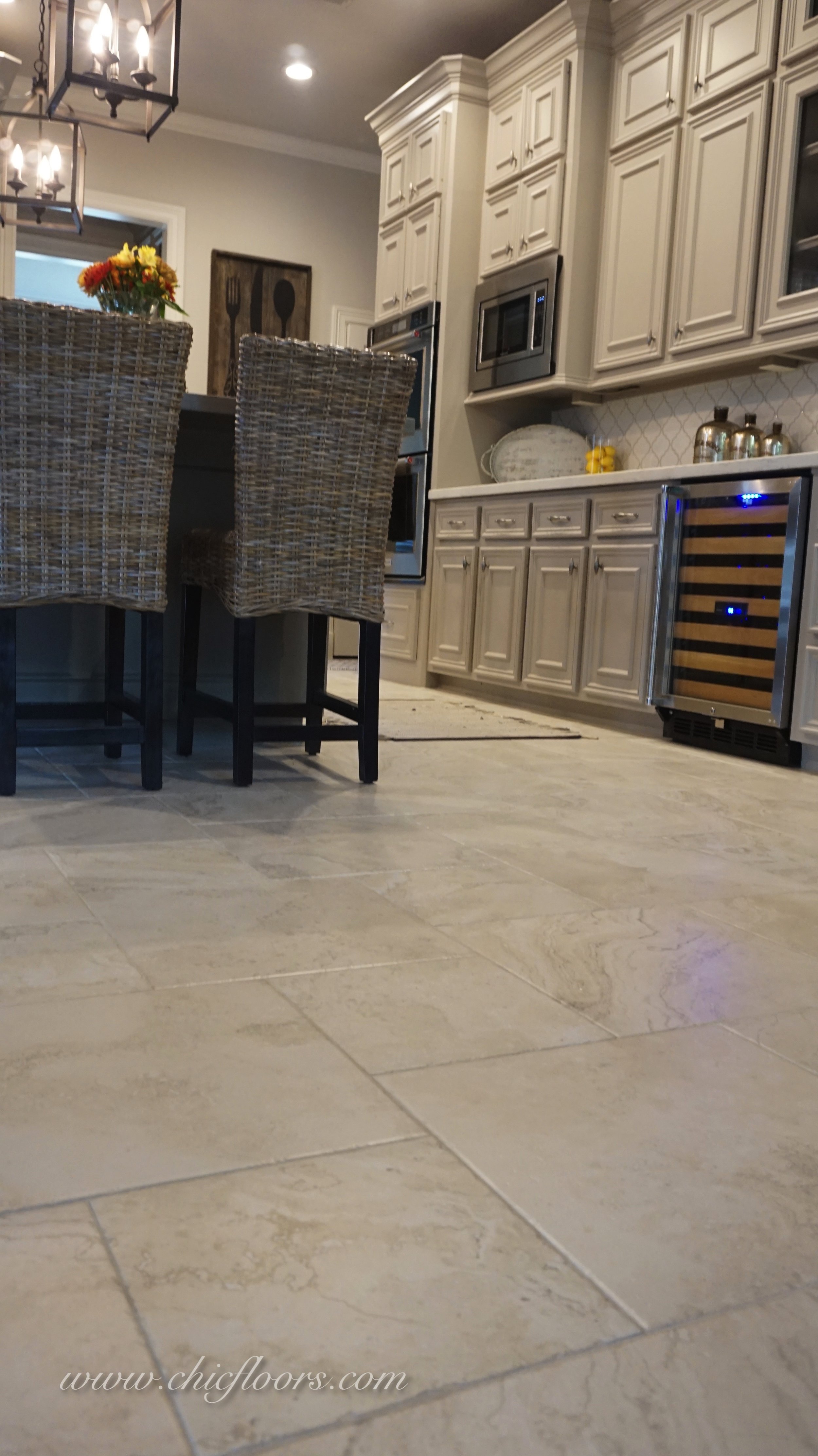 The 18x18 tile pulls together the light gray cabinets, the darker gray island, and the brown island stools.
