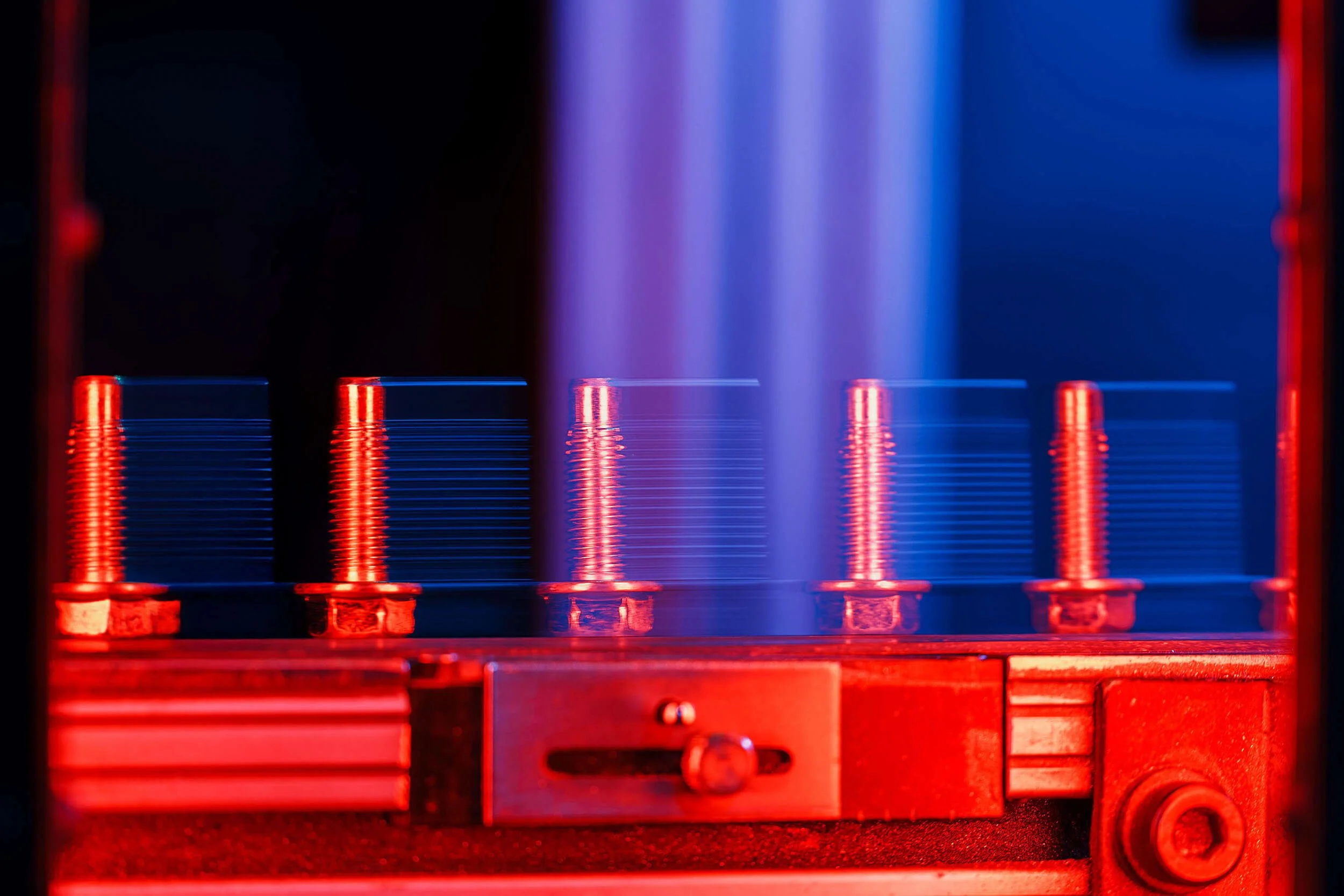 Close-up of a glow discharge plasma display with red and blue colorful lights and metal parts.