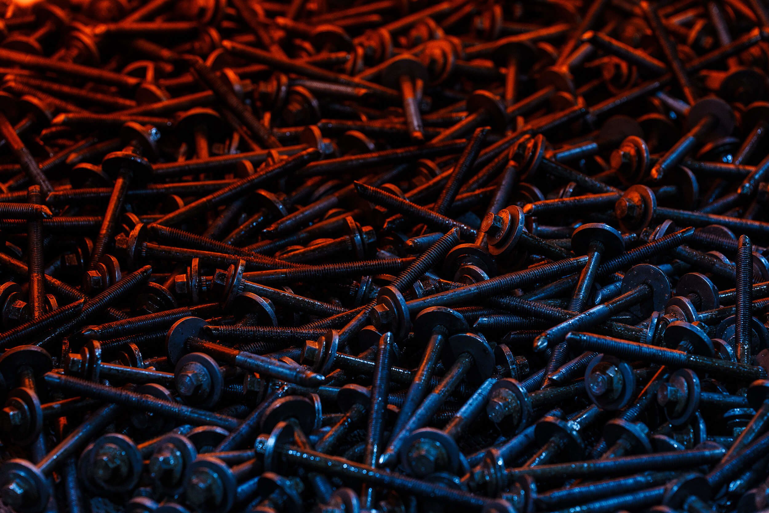 A large pile of black metal screws.