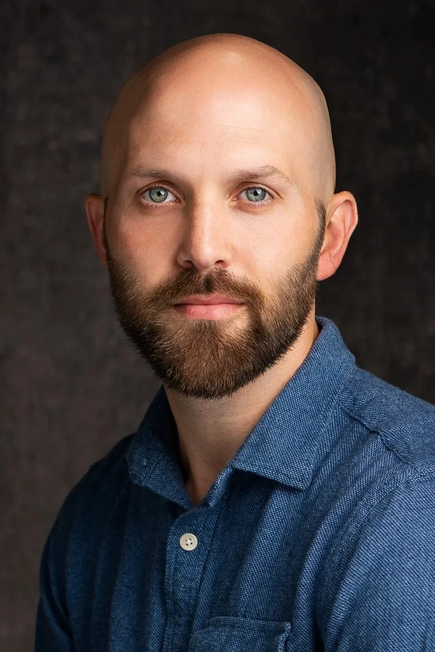 Headshot portrait of Michigan commercial photographer Rob Hall, with a luscious dark beard and dazzling blue eyes