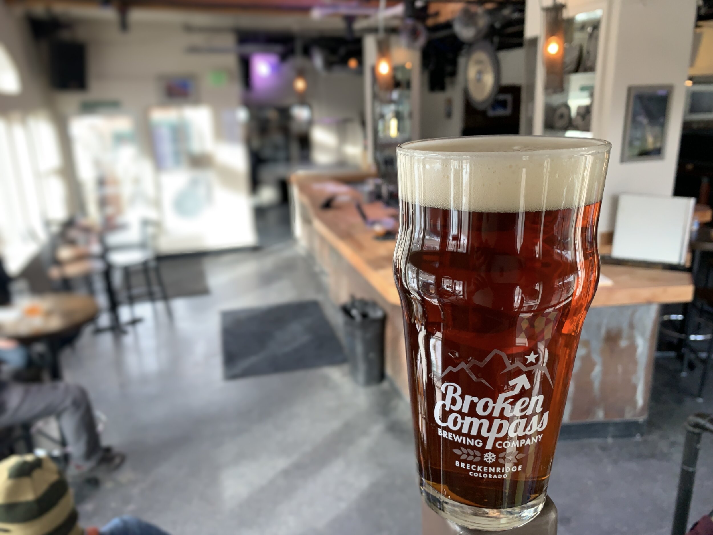 An amber colored beer in a Broken Compass glass