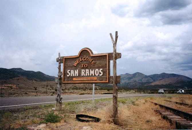 Tattered town sign for the once proud, now dying border town of San Ramos.