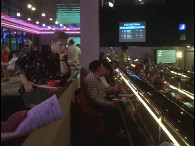 Edward (Ron Eldard) watching his fortunes slip away at the asino sports book betting tables.