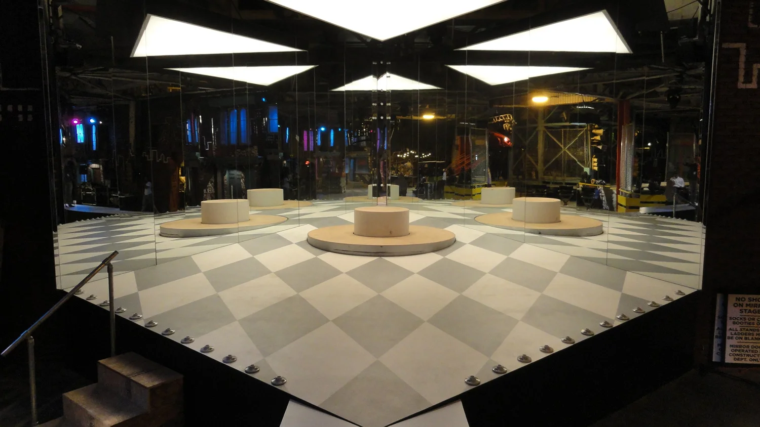 In the story, club Off the Streets is a well known venue for top hip hop acts. This is a stage/set piece built specifically for a performance by the popular young star Roxxie (Coco Jones). It is ultimately a huge triangular, mirrored room for several beats of the song, which creates an infinite efffect, reflecting Roxxie's image and the harlequin-checkered floor thousands of times. Here only two of the walls are in. The third wall was installed by a crane overnight, and consisted of two 12'x16' sliding doors that weighed 1,200 pounds each. 