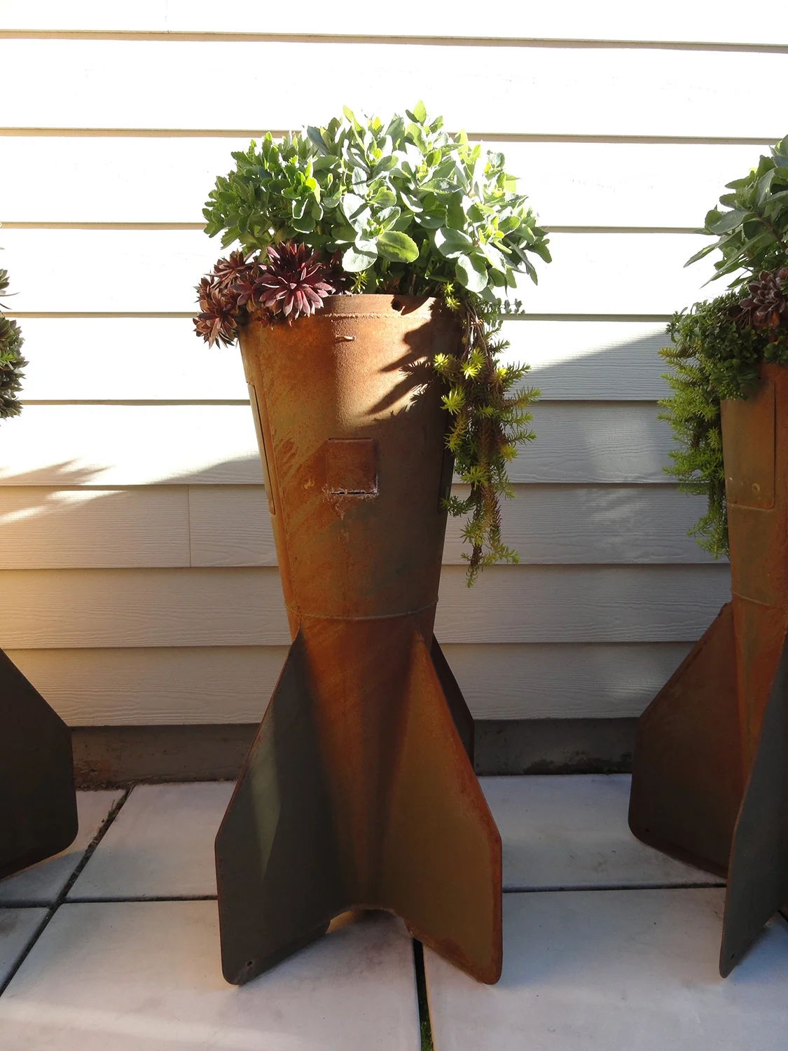 Second World War salvaged 500 lb. bomb-tails modified for succulent container gardens.