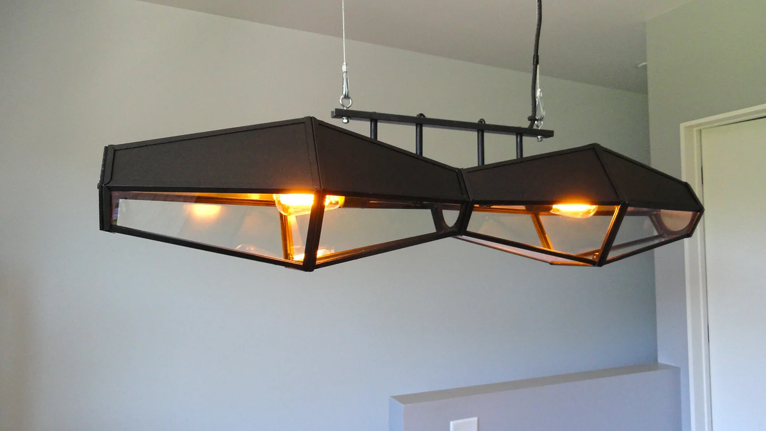 This strange, Zeplin-like dining room or desk light is actually two 1970's, Colonial style porch sconces I found at a second hand store. I stripped away the faux, decorative bits and found I could reconfigure them because of unversal bolts and threaded holes used to assemble them. I removed the glass in what became the top half and made aluminum pieces that reflect the light downward. 