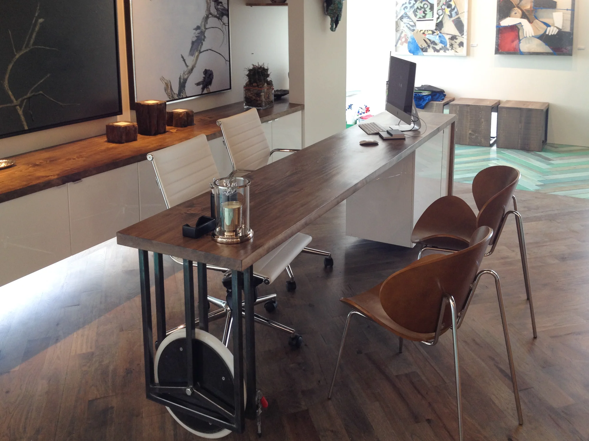 We wanted to give the client the maximum flexibility in activating the gallery for different events. We designed and built this desk, shown here in it's normal, workday position. The wheel can be unlocked, allowing the desk to pivot 90 degrees into the archway of the office to become a bar of buffet for parties. The electrical supply for the computer runs up through the pivot point from the basement