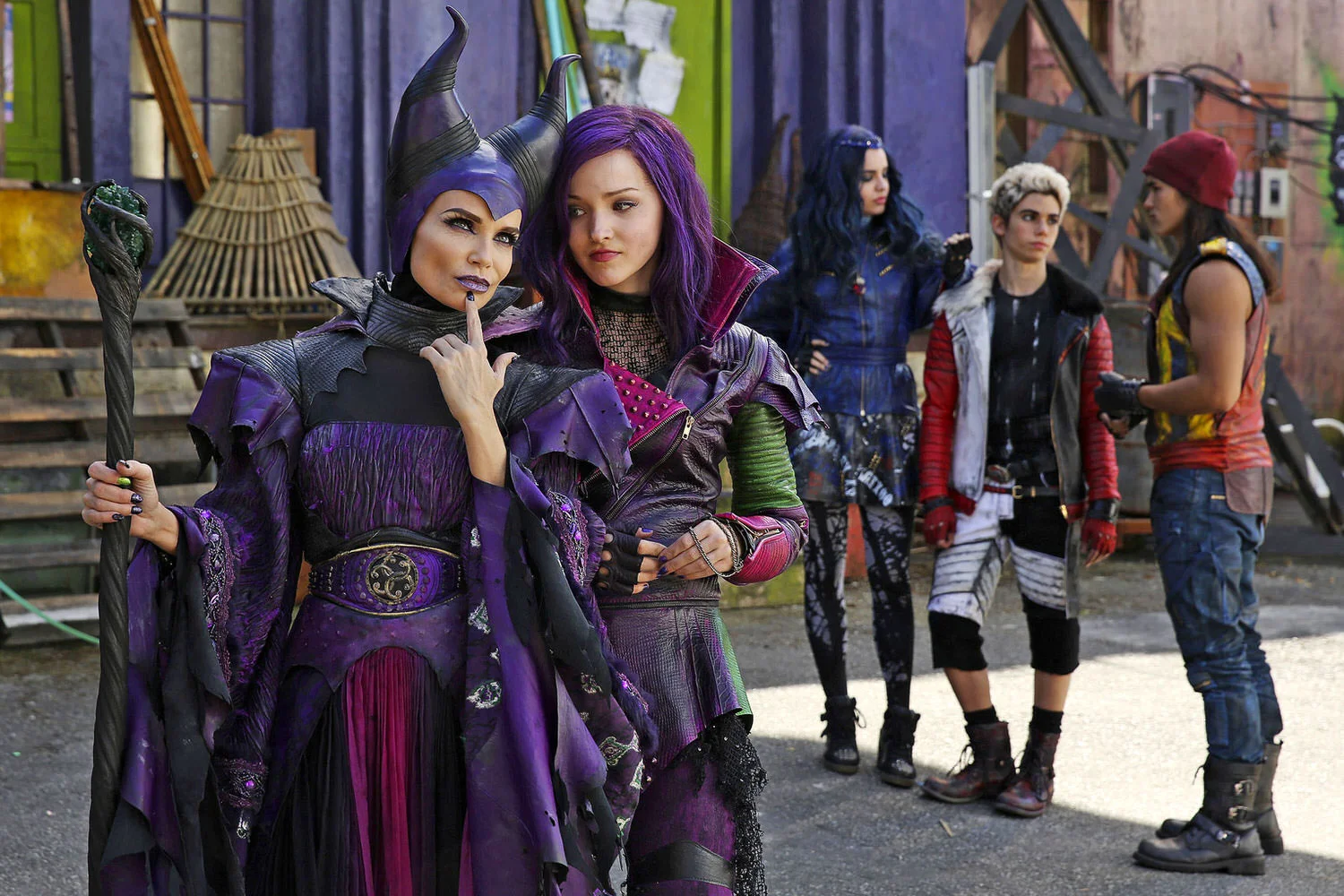 Mal (Dove Cameron) conspires with her mother Maleficent (Kristin Chenoweth) on the Isle of the Lost. The Isle is a combination of Alcatraz, a Turkish Bazaar and John Water's Baltimore. With the entirety of Disney's stable of villains imprisoned here, the color palette had to reflect their very particular taste. After a careful study of classic Disney villainy, I took all their purples, blacks, burgundies, and acid greens, and drenched them with 20 years of soot, rust, grime and grit. I called the resulting palette "Dirty Candy". (Disney Publicity photo)