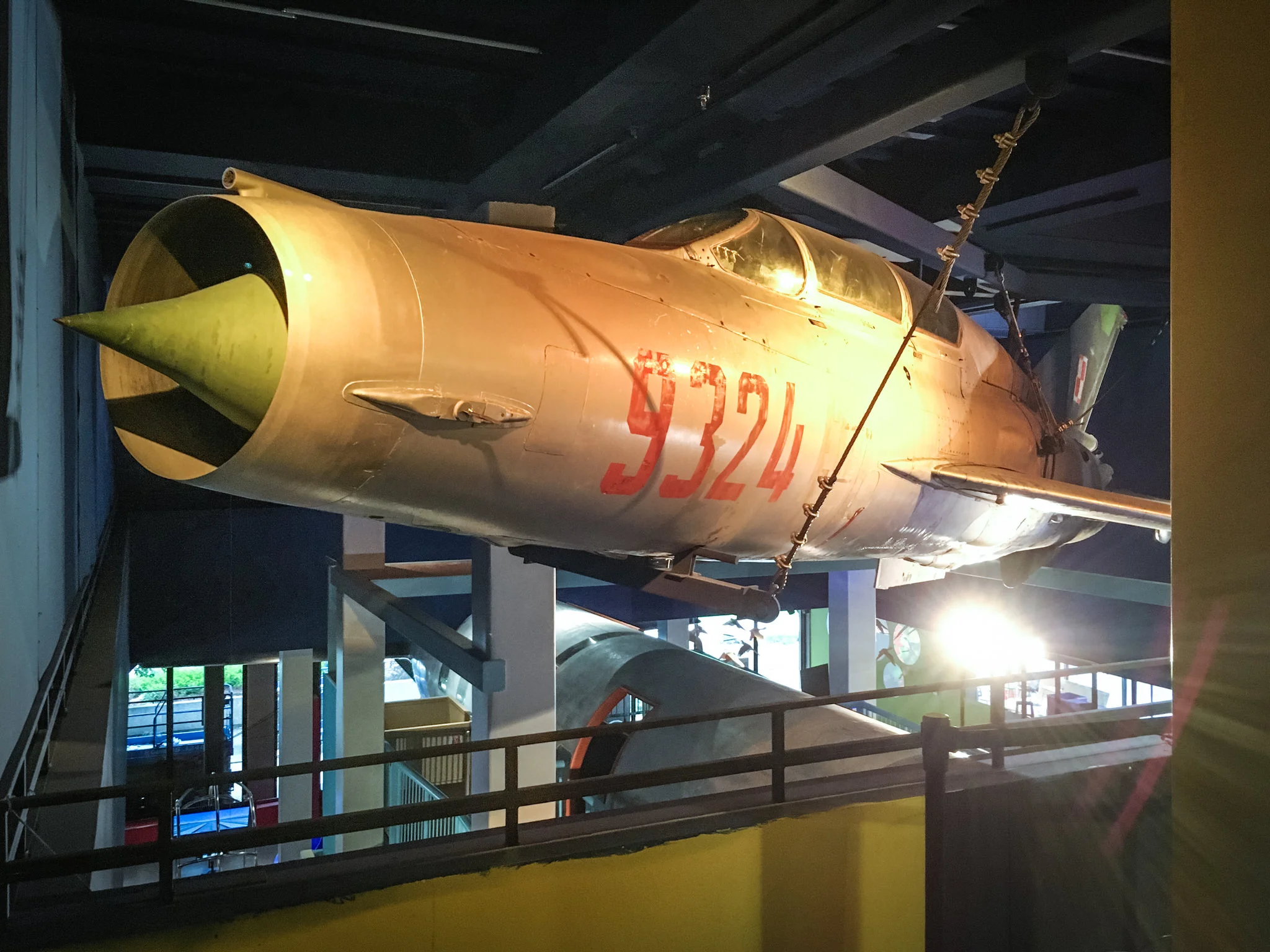 As floor space in the exhibit was limited, we found the only place we could put the Mig-21 was up. And so we did. It fit almost perfectly, with a bit of it's nose and a wing tip just peeking into the second floor galleries.