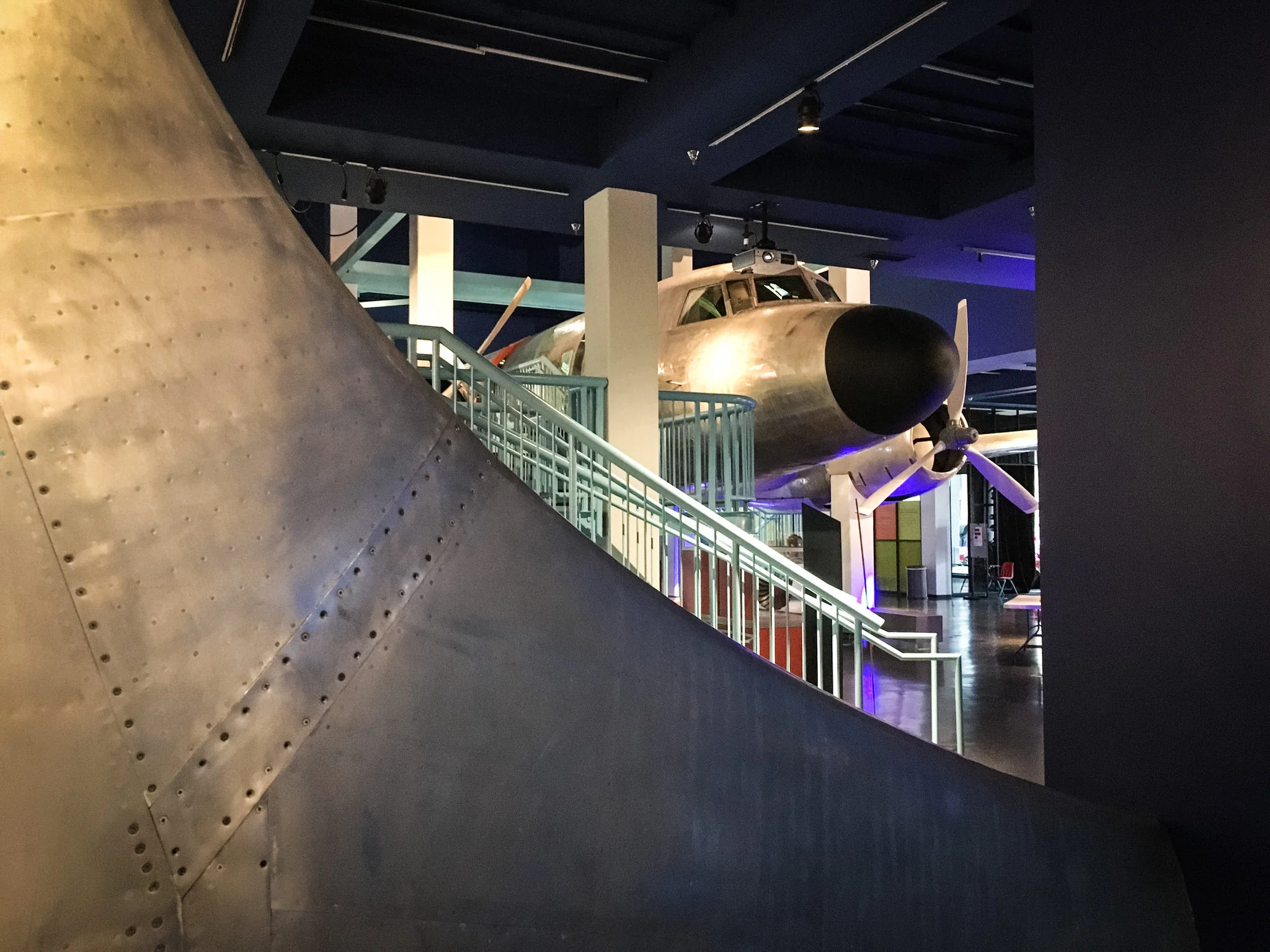 The entry vestibule offers a tantalizing peek into the main gallery. We chose the huge vertical stabilizer of the C-131 as an artful curved barrier that pairs beautifully with the graceful arch of the Tunnel of Dreams entrance.
