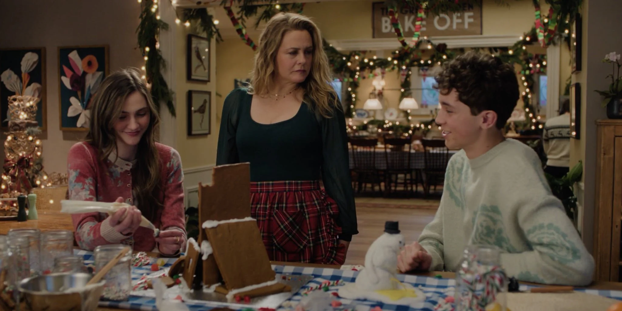  Kate’s family (Emily Hall, Alicia Silverstone, and Wilder Hudson) gearing up for a gingerbread contest in her kitchen, looking back toward her dining room. 