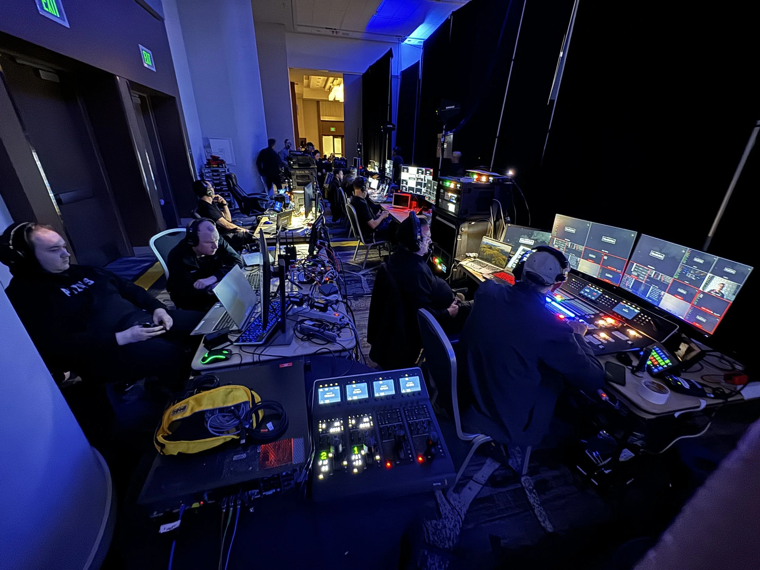 Talon AV crew at a production control desk, wearing headsets and focused on multiple monitors and mixing consoles during a live show.