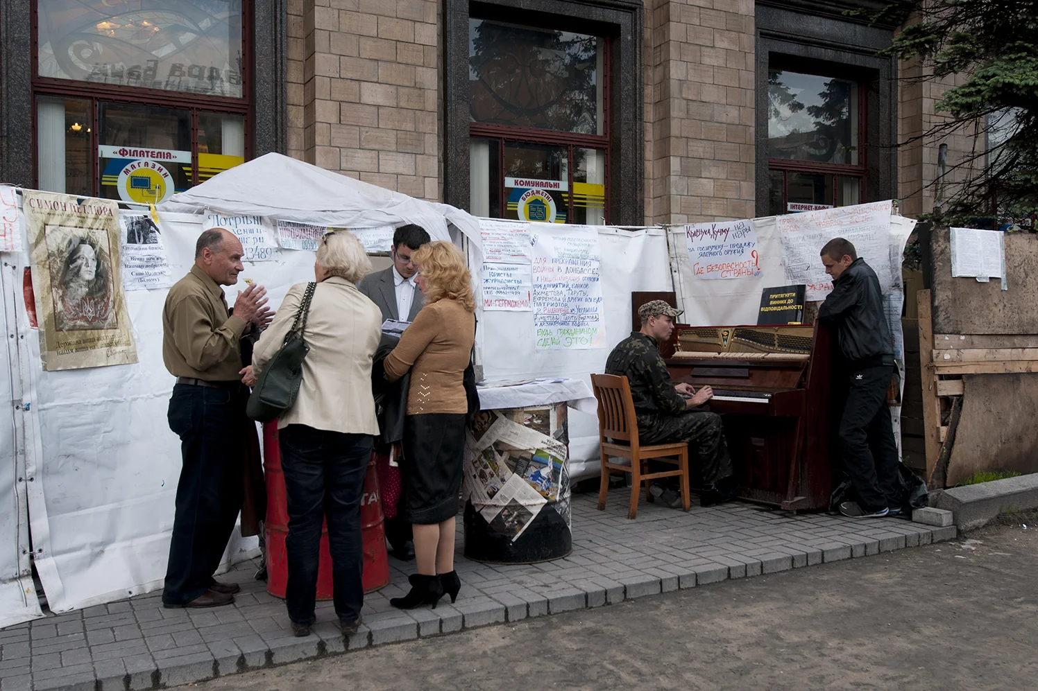 An activist in uniform playing the piano in front of the Media center of 