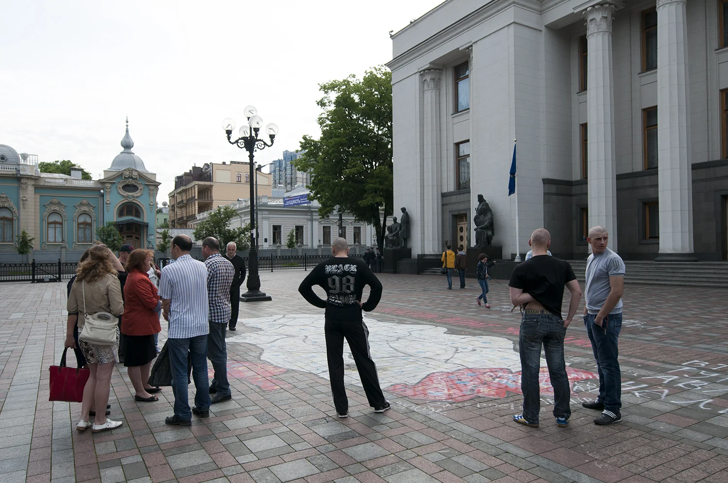 People standing over a map of Ukraine showing the areas under control of the Pro Russian Forces, with the names of three politicians accused of being partially responsible of the current situation 