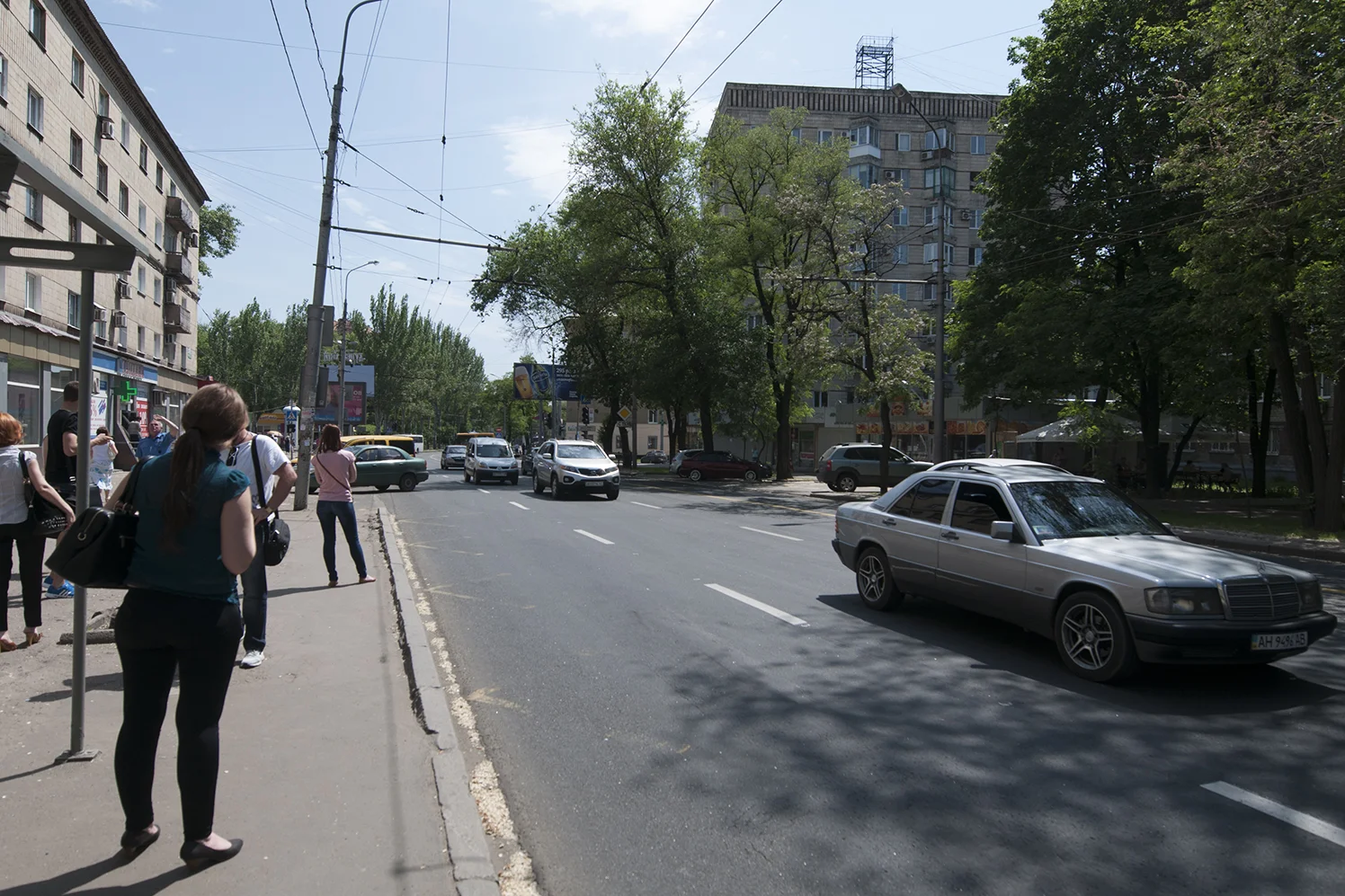 People waiting for the bus as the sound of the airport's bombing resound in the street of Donetsk