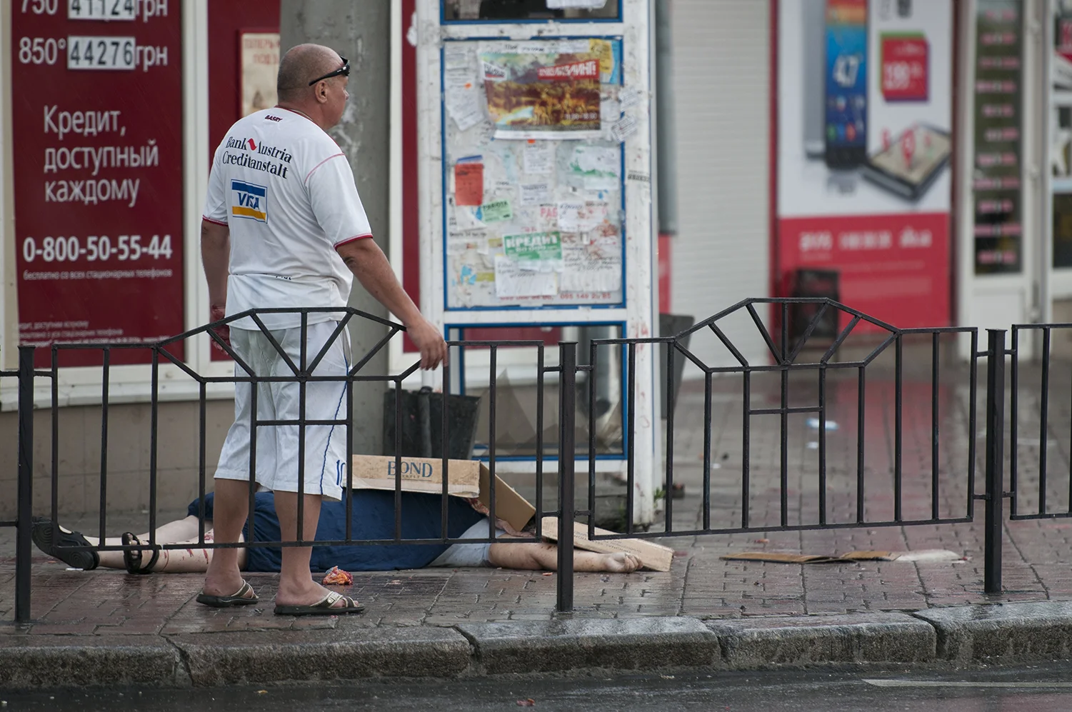 A man standing next to an elderly woman who was shot in the head. More than an hour and a half after this pictures was taken the body is still laying on the street, at least two ambulances came there without taking her corps away