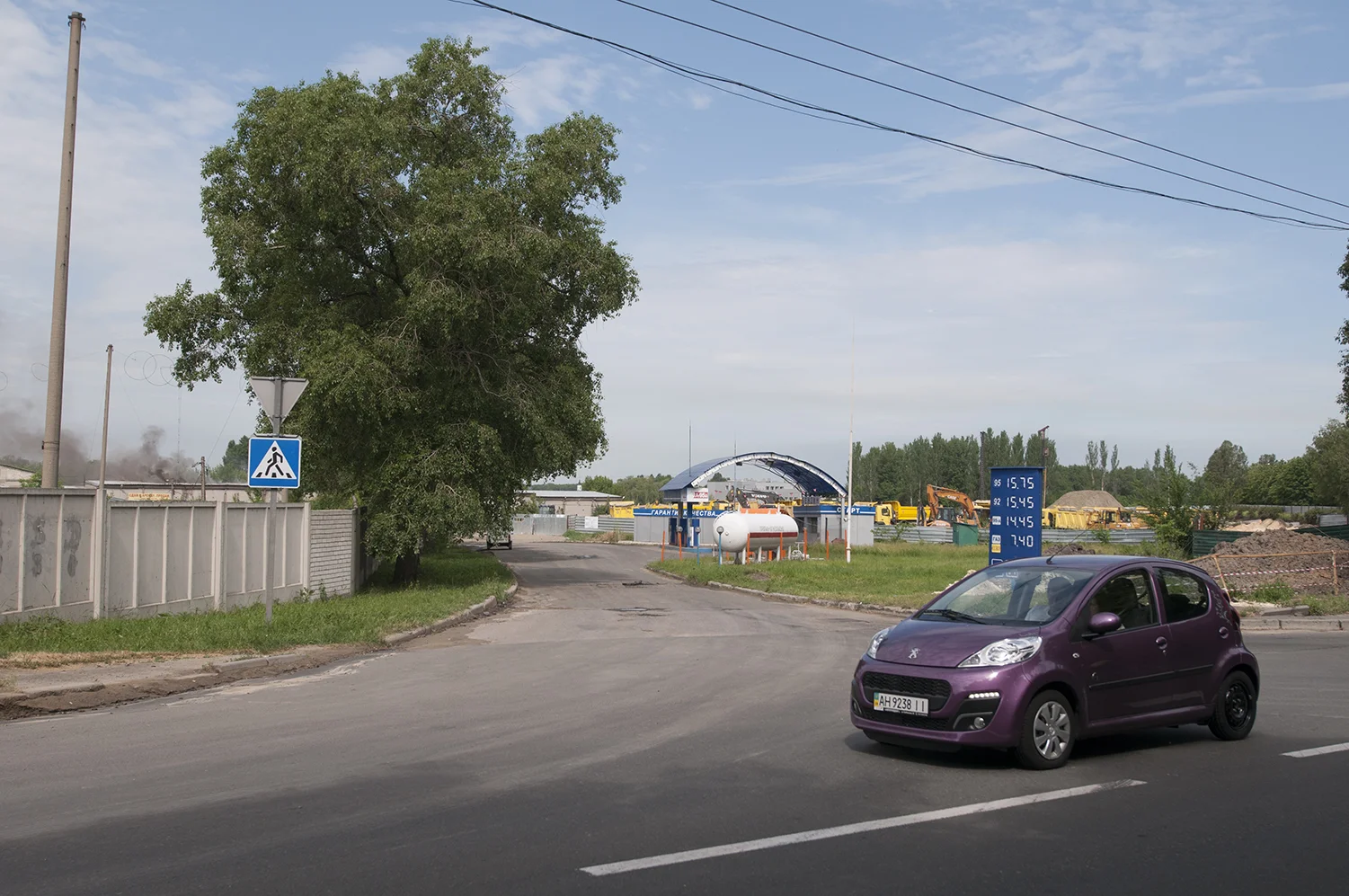 Smoke coming out of warehouses near the the Sergey Prokofiev Airport as car car pass by