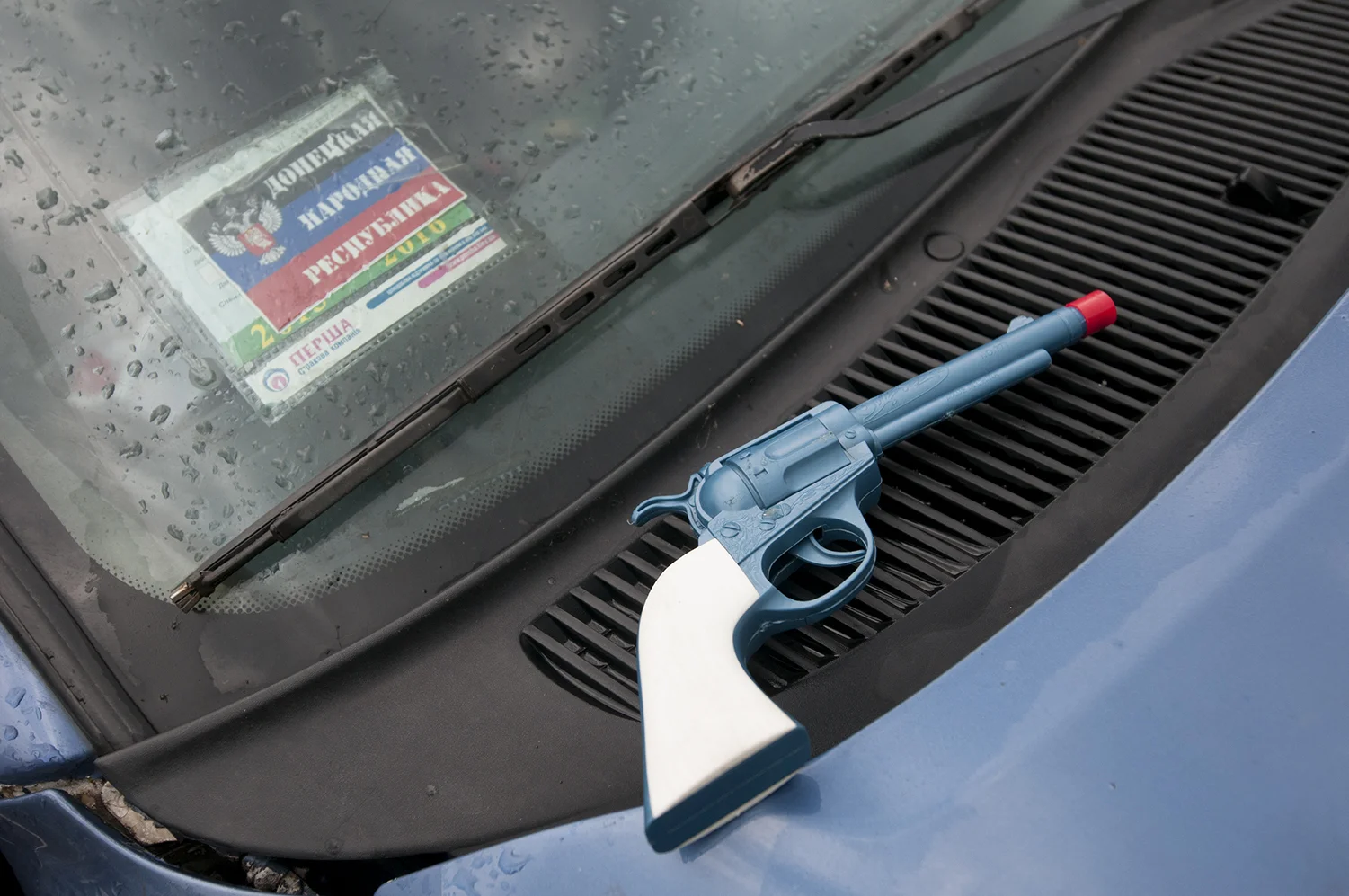 Toy gun on a car's hood parked in front the ODA building 
