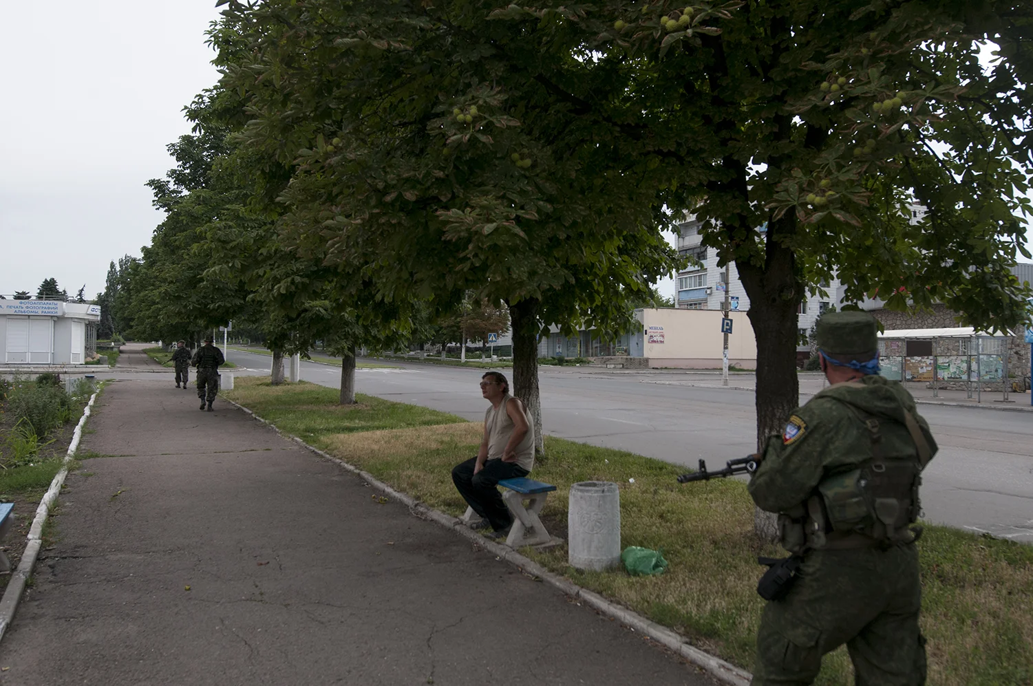 Man sitting on a bench located in the middle of the empty town of Marinka