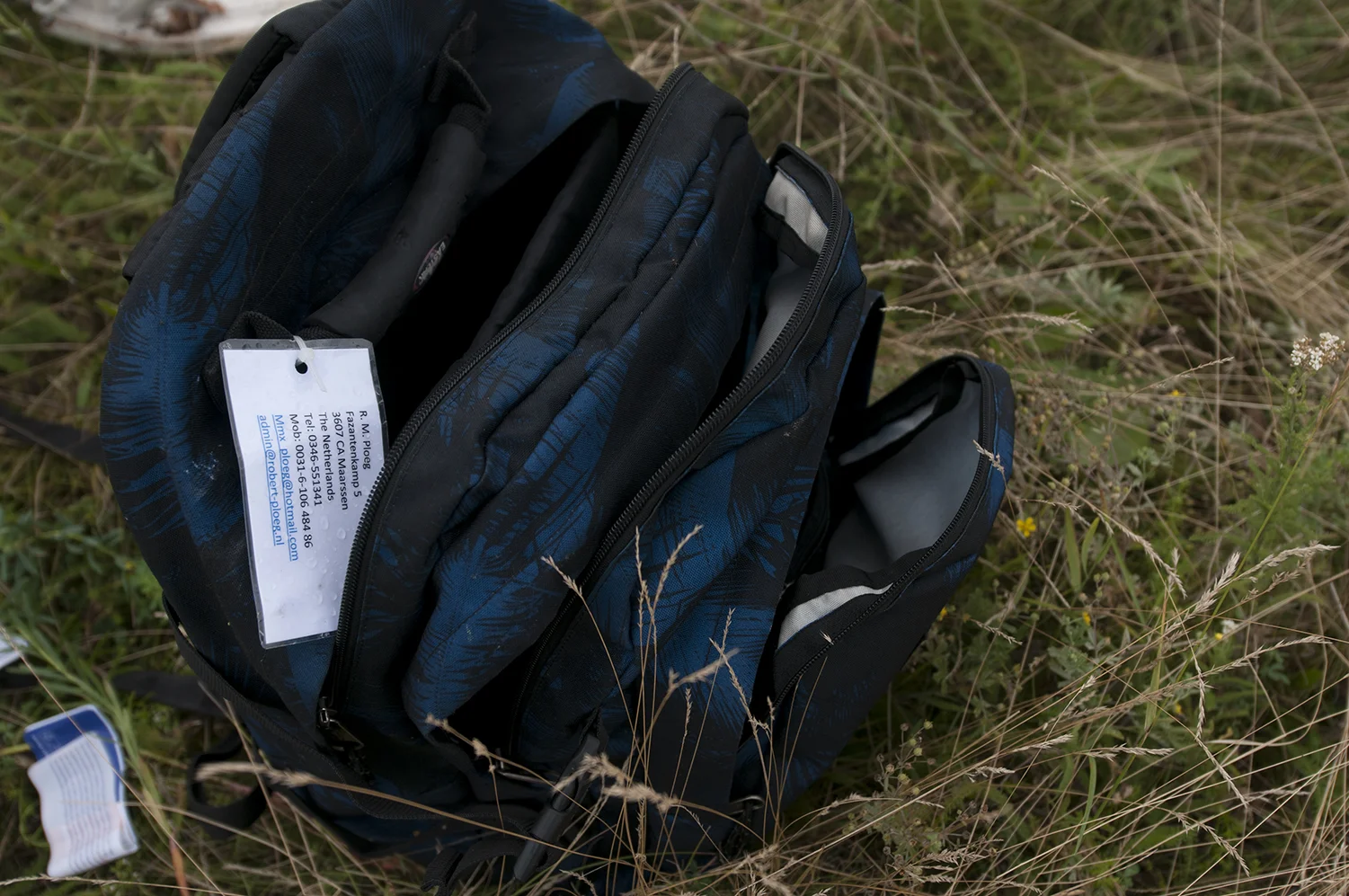 An open and empty bag belonging to one of the passengers sitting on the ground, some looting have been reported on the crash site during the night.