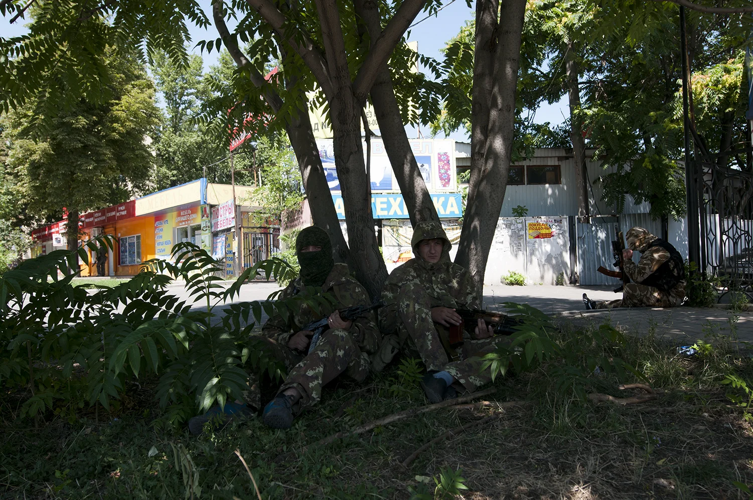 Armed men waiting in the shade