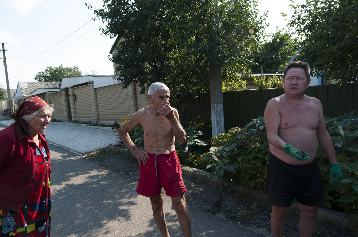 A man displaying a piece of metal that he claim was part of a missile that stroke in his residential area as his neighbour watch