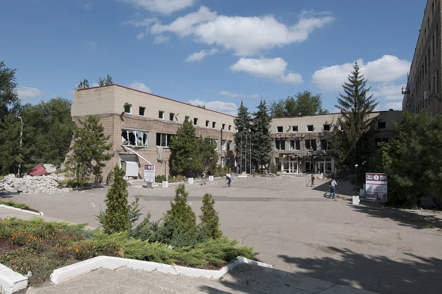 Volunteers cleaning the square of Donetsk Regional museum which got hit the previous afternoon 