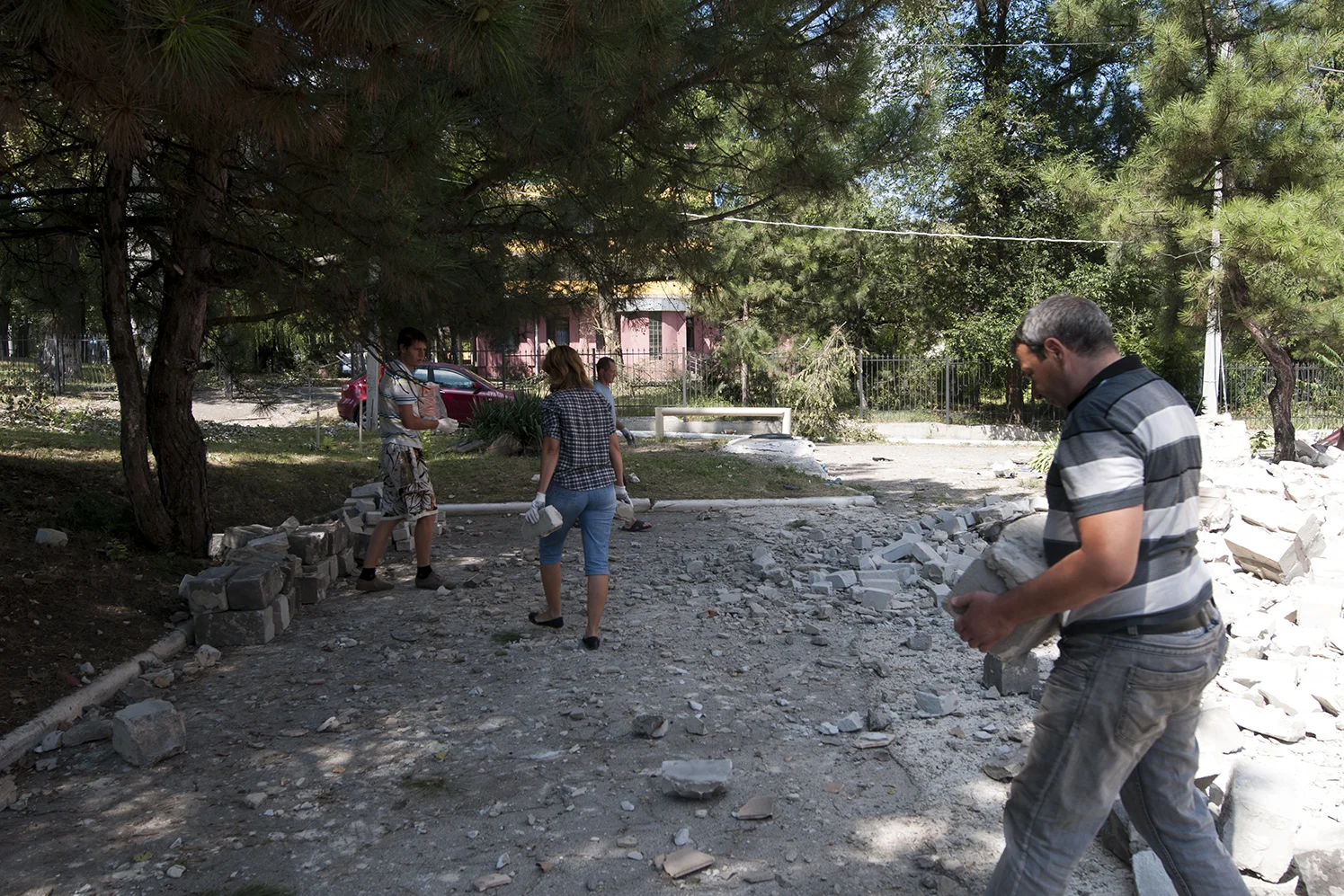 Volunteers pilling up the rubbles from a collapsed wall 