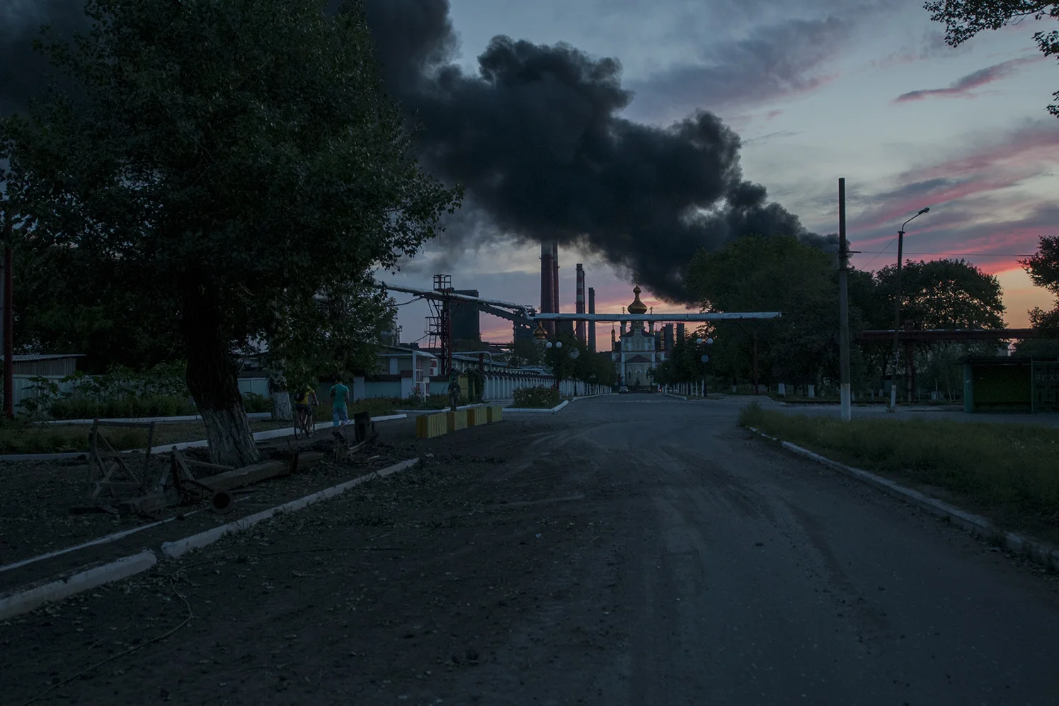 Dark smoke rising over church 19 as the sunset down