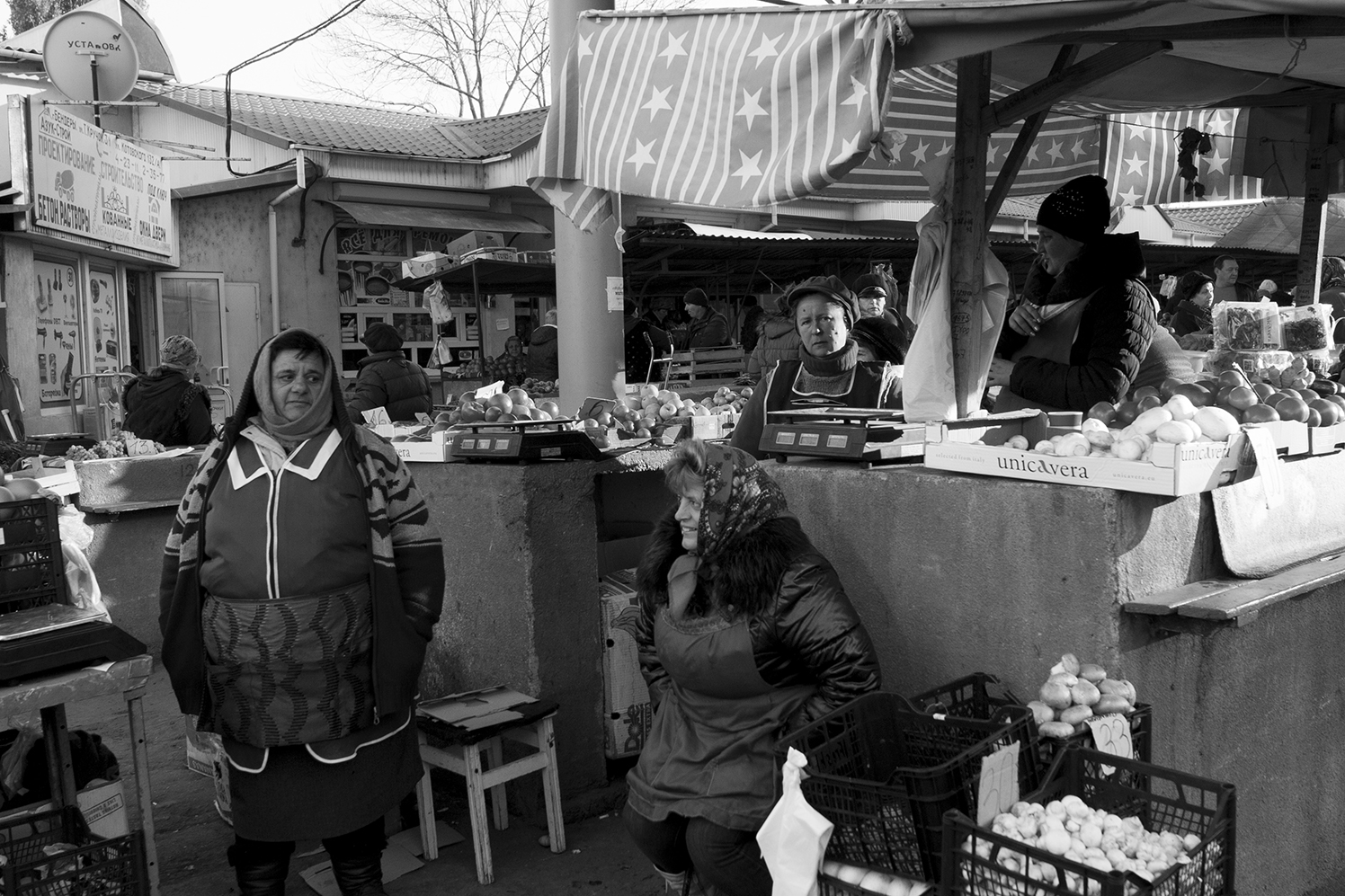 Women standing in the middle of their vegetables