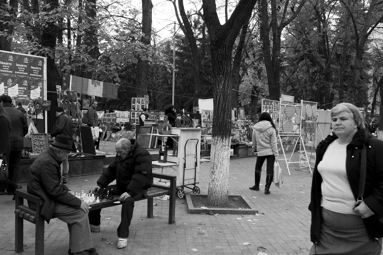 Old men playing chess on bench in fornt of the souvenir market