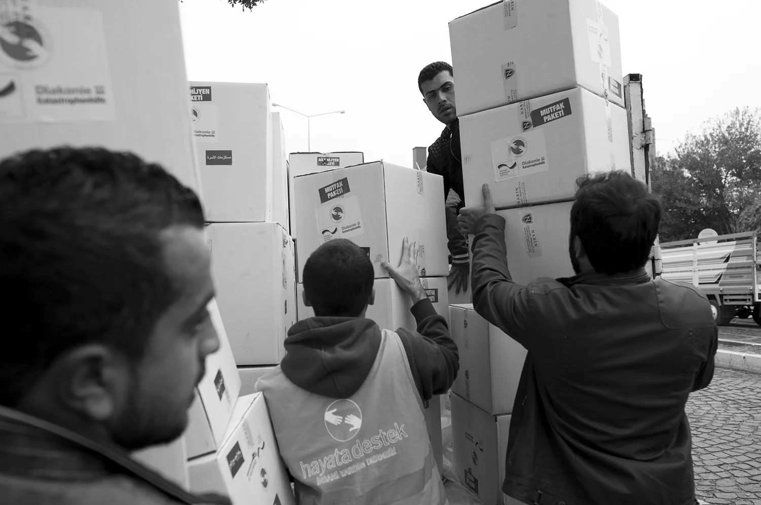 Volunteers and Hayata Destek workers finish loading a truck with aid boxes which are designated for Syrians living outside of the refugee camps around Suruç.