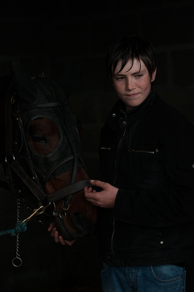 Kevin a young apprentice and his horse in the stables.