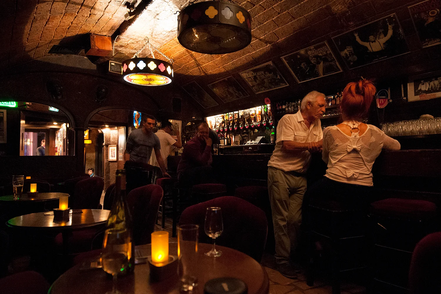 People sitting at the bar of the Caveau De La Huchette which has been a Jazz club since 1946.