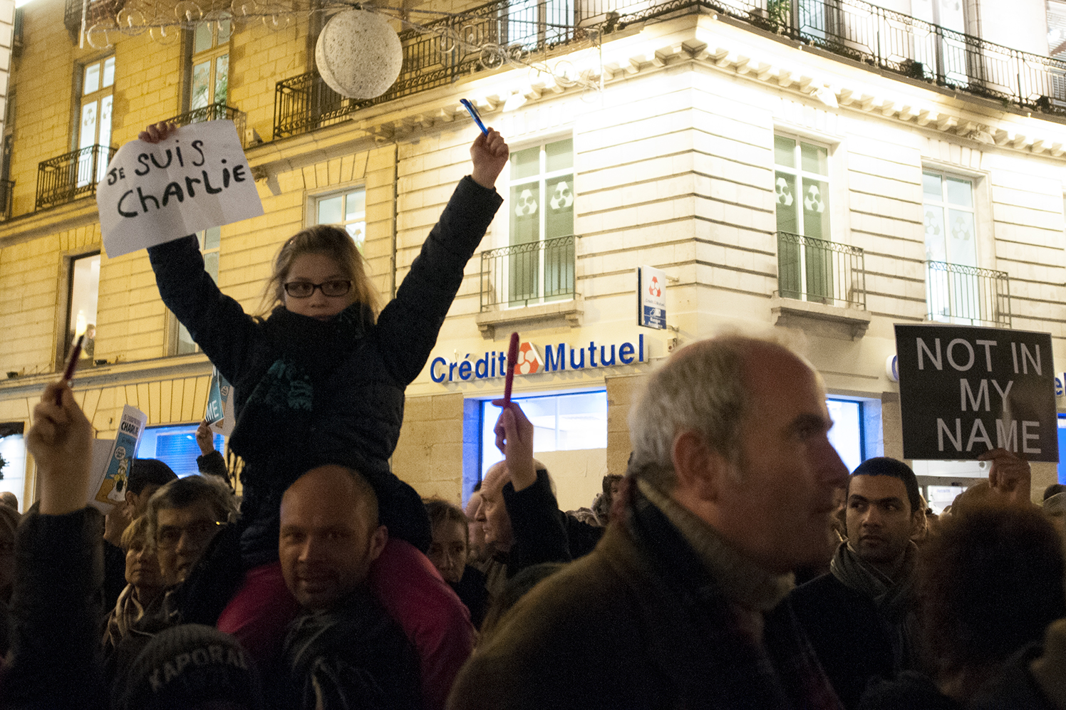 little girl holding up a pen and a sign saying "I am Charlie" 