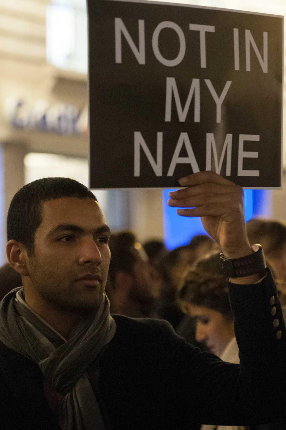 A man holding a sign denouncing the terrorist attack against Charlie Hebdo
