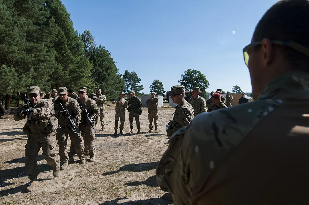 U.S. paratroopers demonstrating how to clear a room to Ukrainian soldiers.