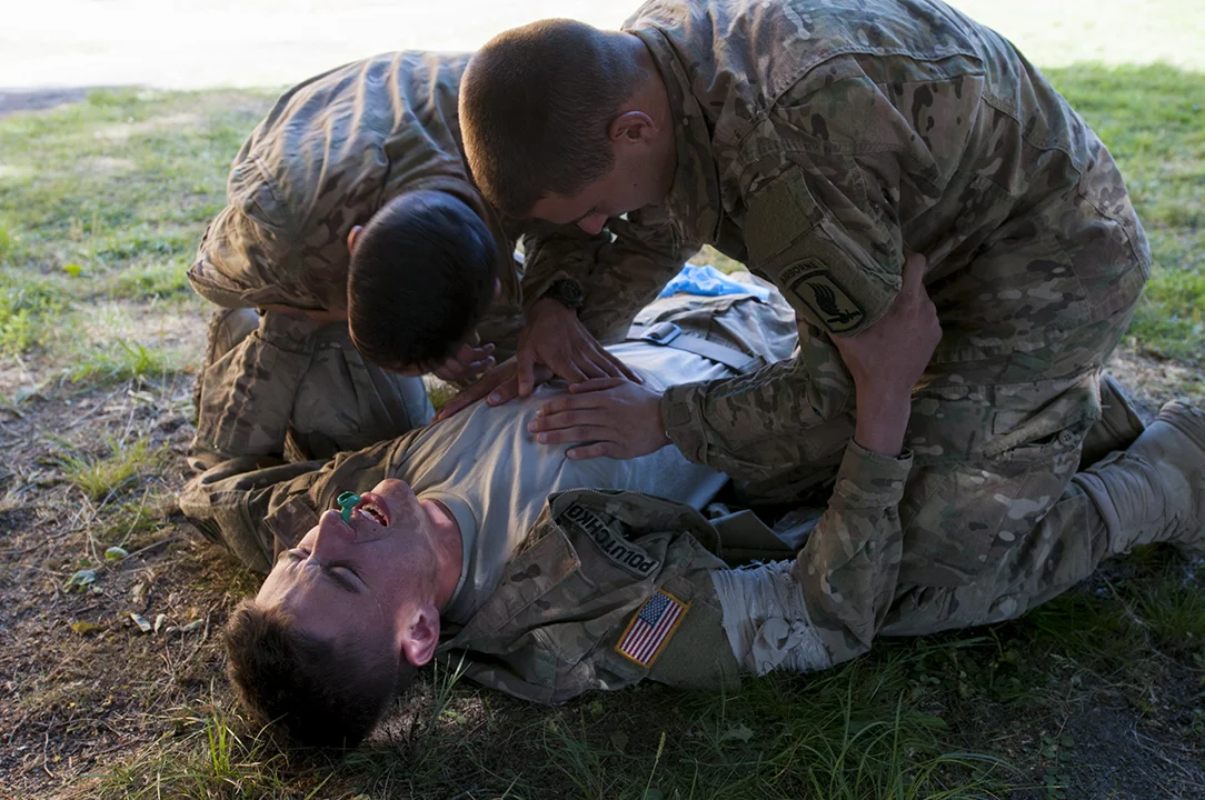 Paratroopers inspecting the chest of their comrade during medical training. 
