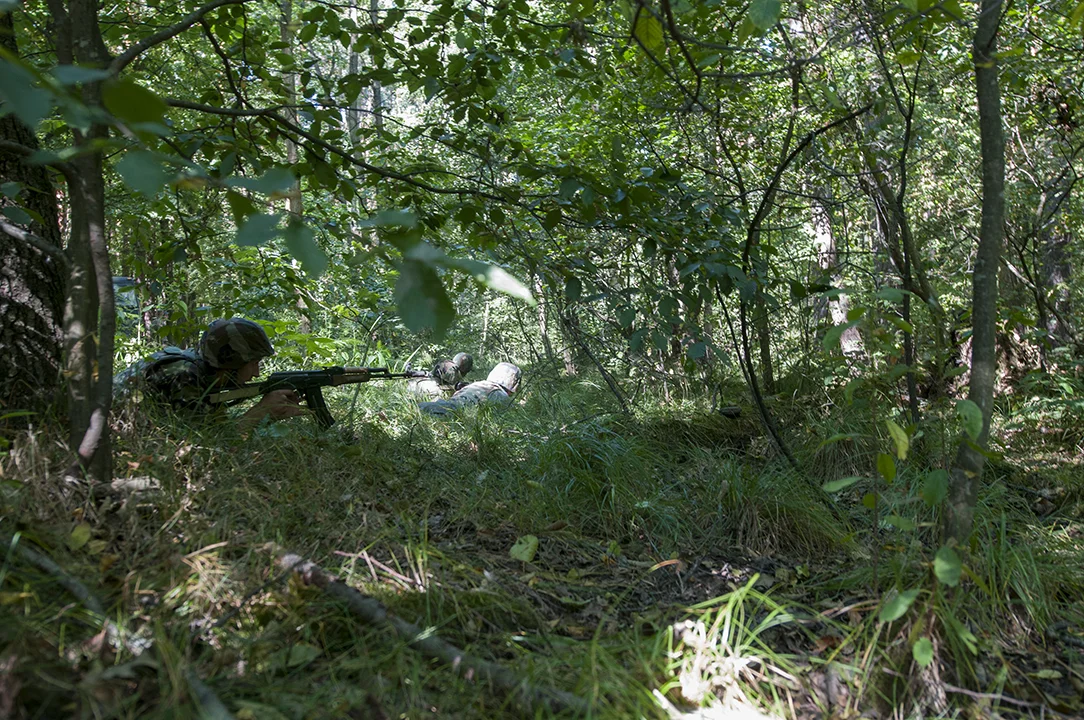Ukrainian soldiers hitting the ground and returning fire after being ambushed by U.S. soldier during the patrol exercise. 