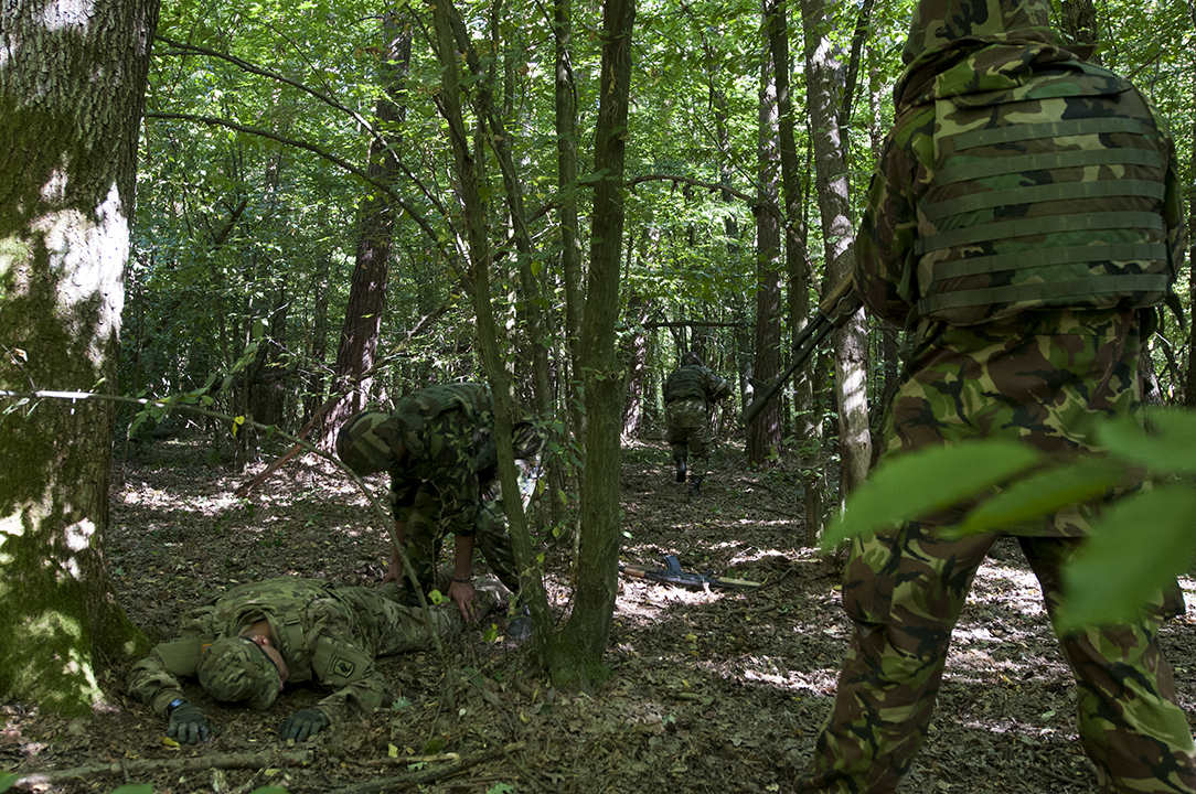 Ukrainian serviceman searching the U.S. paratrooper as his comrades secure the area.