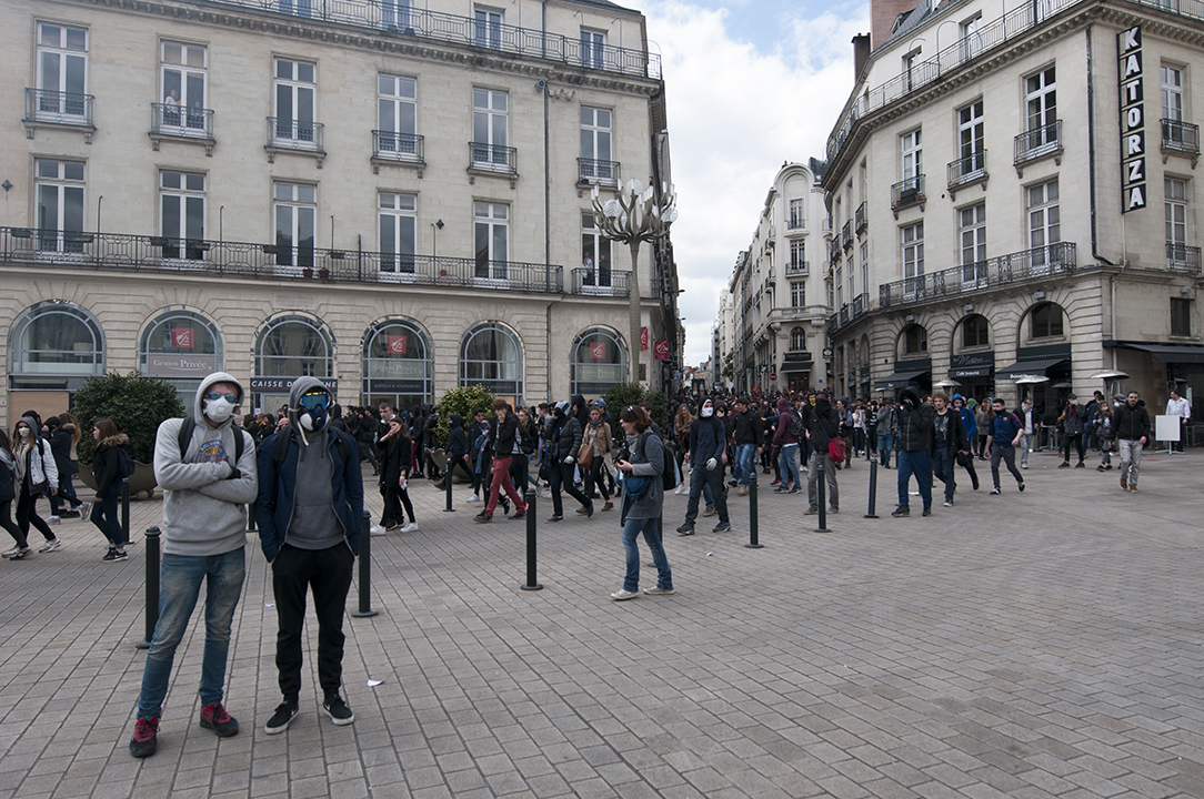 Masked protesters standing in front of the rally.