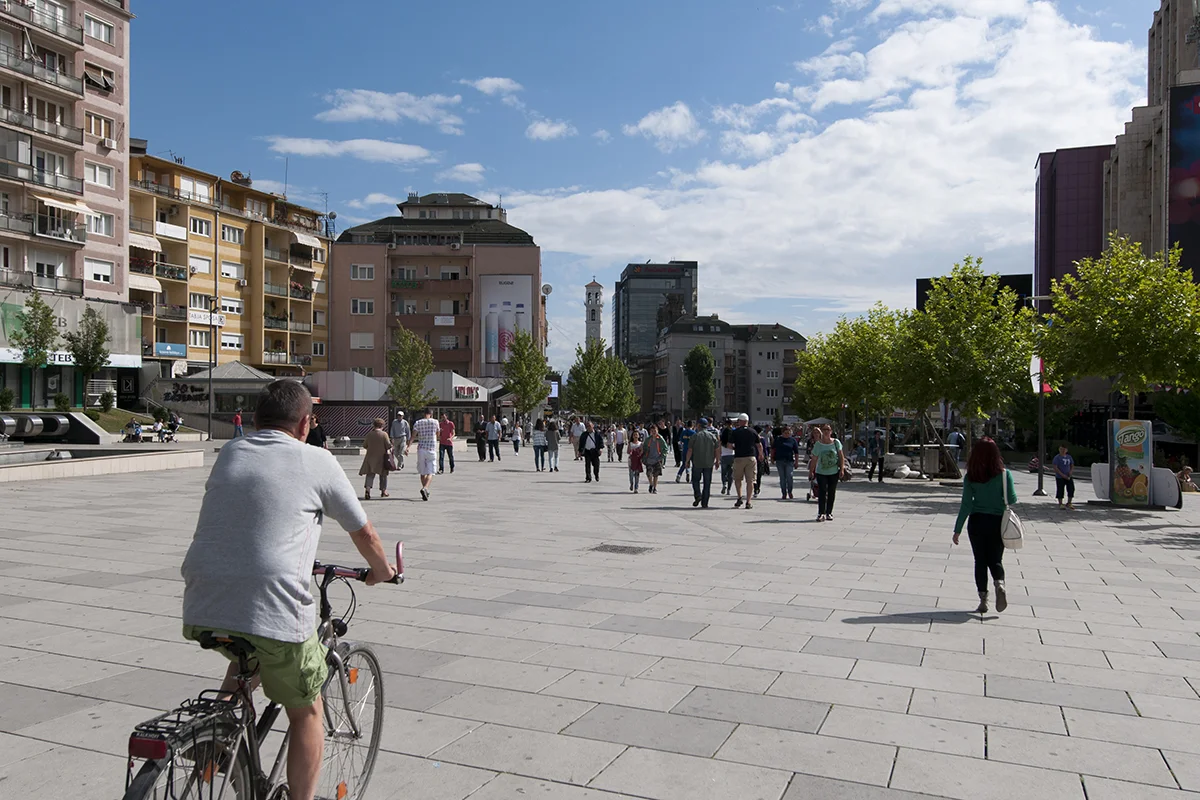 A man ridding his bicycle on Bulevardi Nënë Tereza.