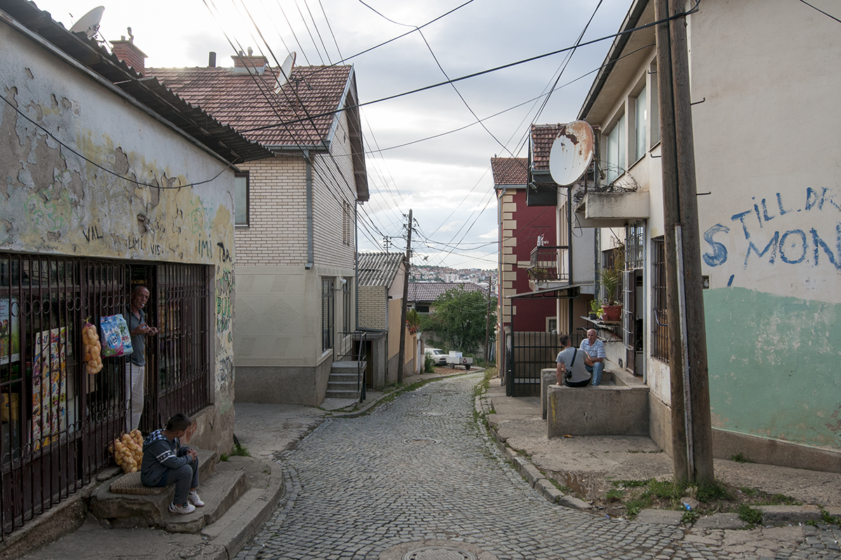 A middle-aged man and a child on the door step of a small grocery store.