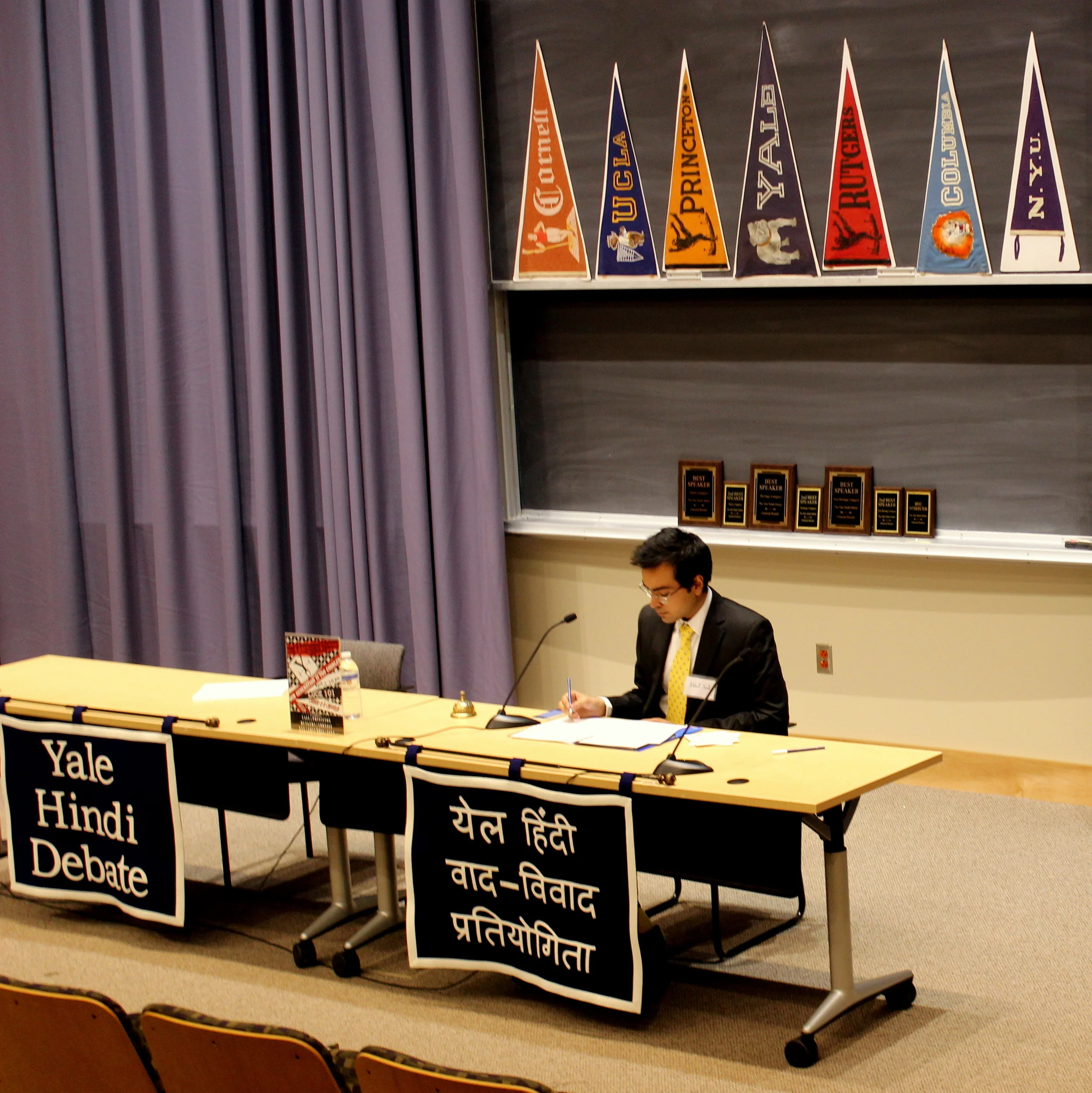 YHD President and Chairperson Akhil Sud, SM '16, with YHD plaques and banners, under pennants heralding our guests (courtesy of Americana Memories ). 