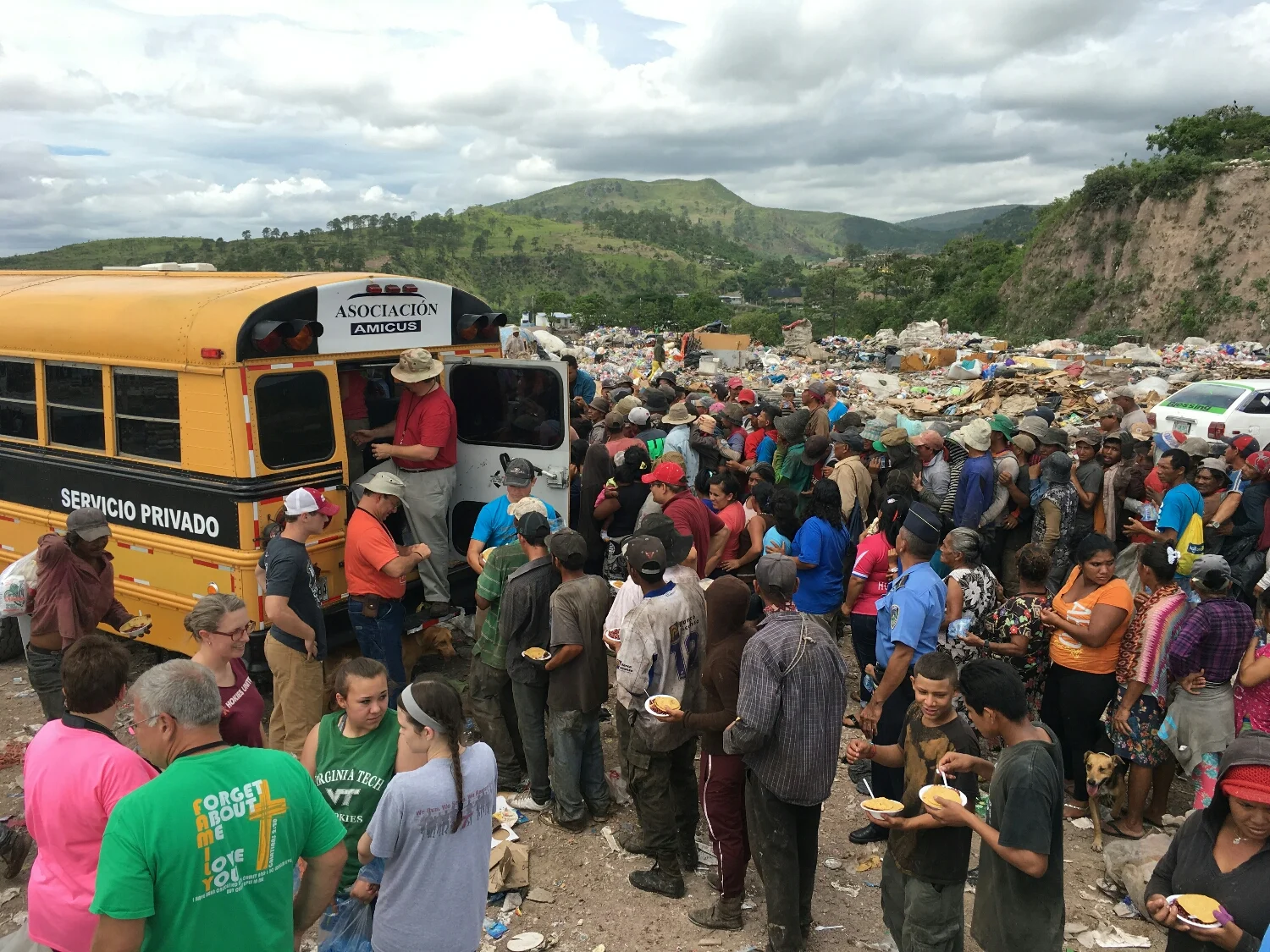 The pickup is hidden by the bus. The nearest line is where they waited for the bags of food. They had to have a ticket in order to get some.