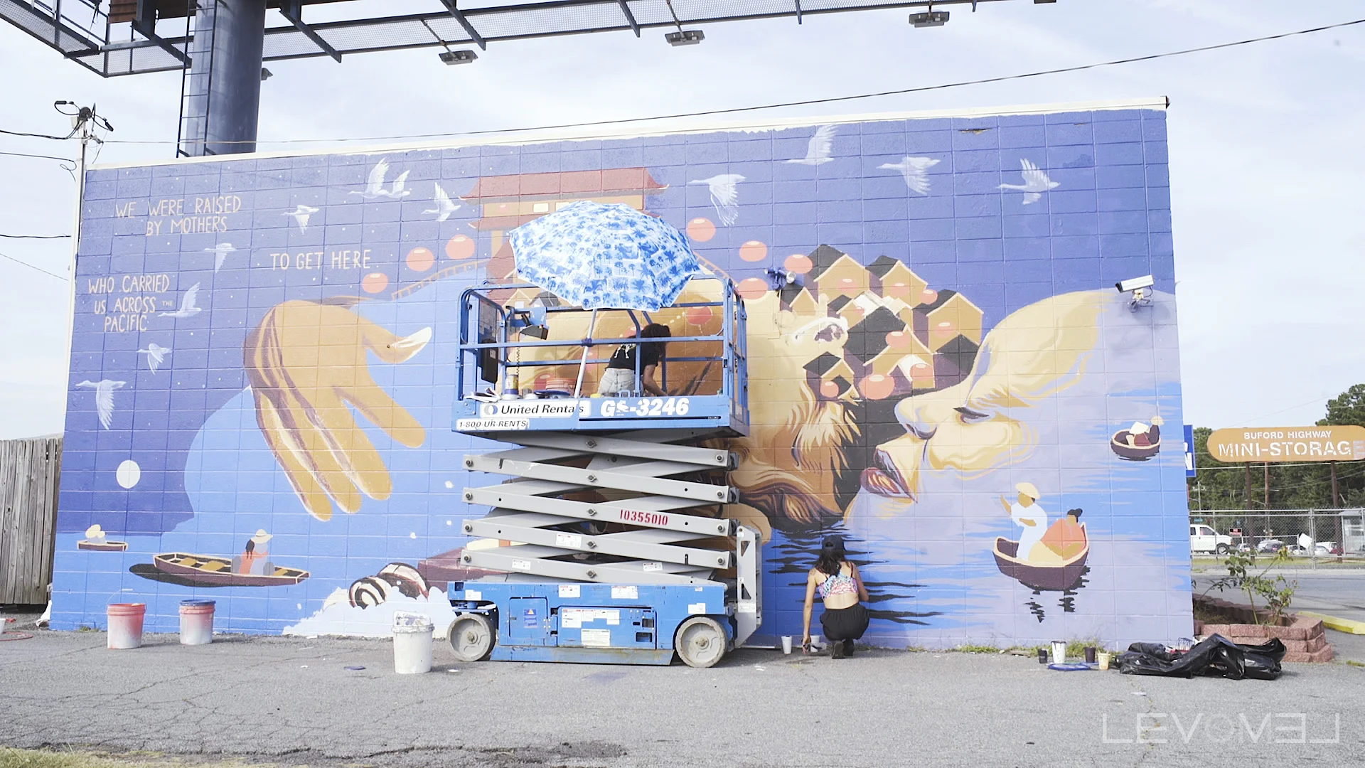 Jess Snow putting up one of TWO beautiful murals on Bufford Highway last week.