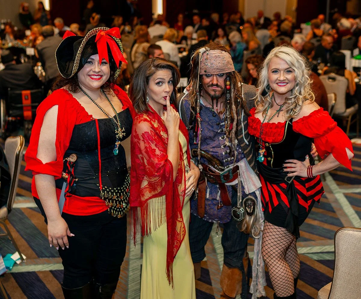 Kaitlin Monte poses with attendees while emceeing a gala for Dive Pirates Foundation.