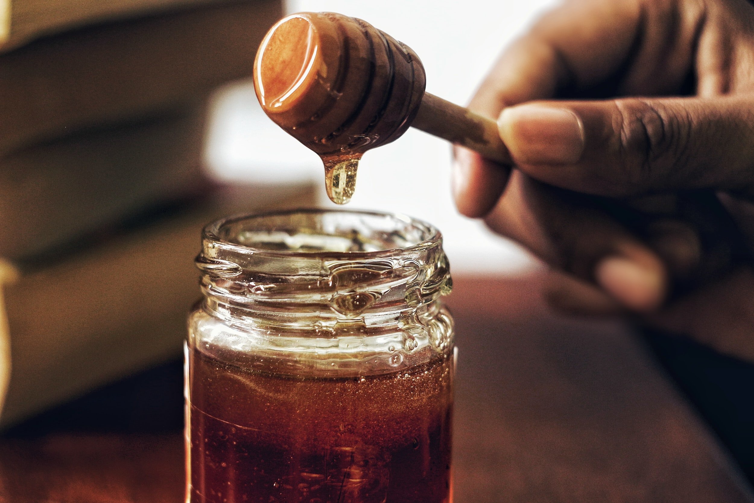 用木勺从罐子里舀蜂蜜