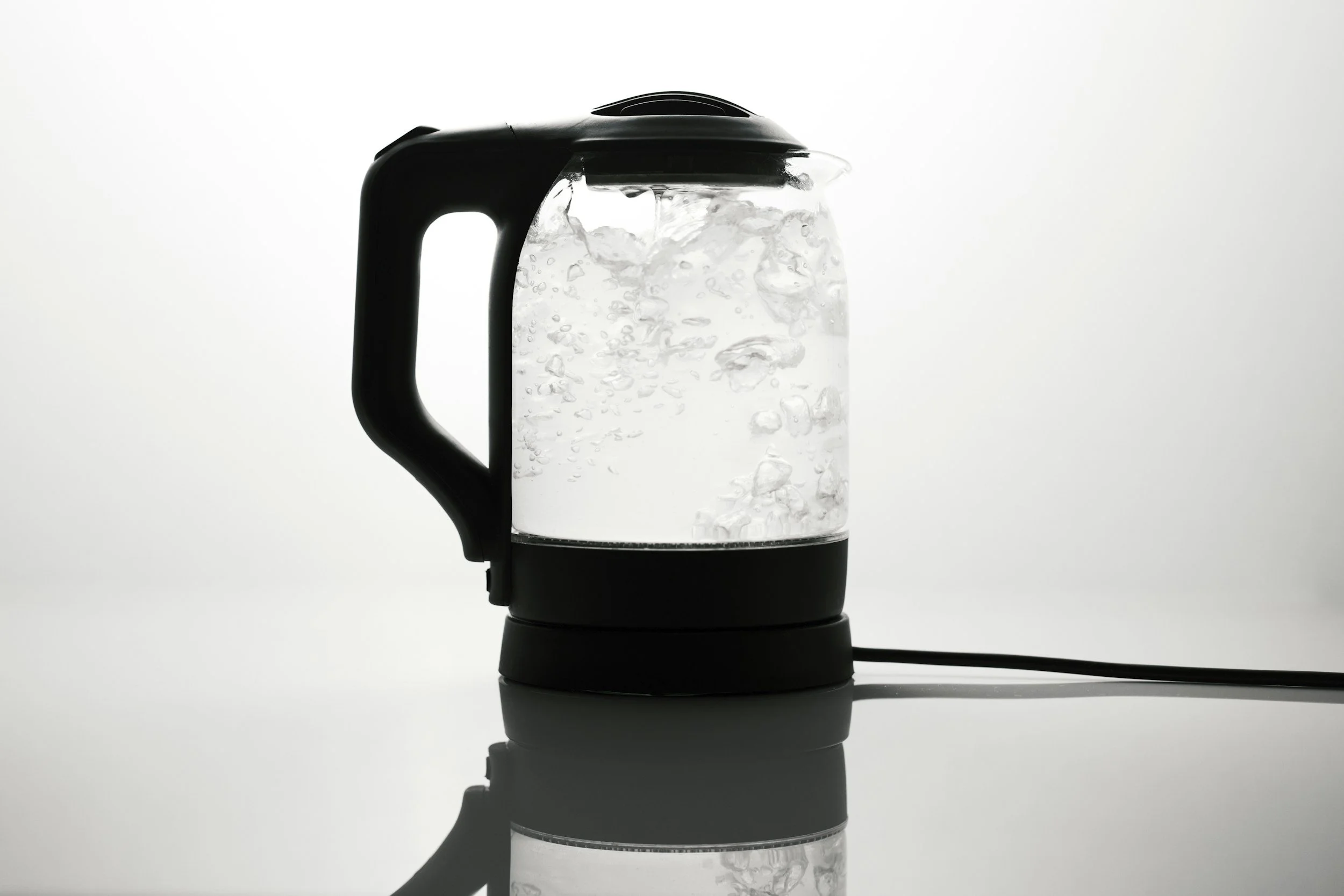 black and white photo of an electric kettle boiling water